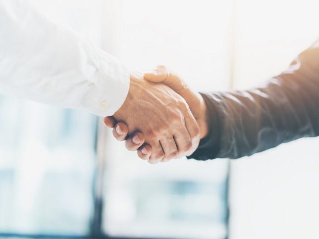 Business partnership meeting. Picture businessmans handshake. Successful businessmen handshaking after good deal. Horizontal, blurred background